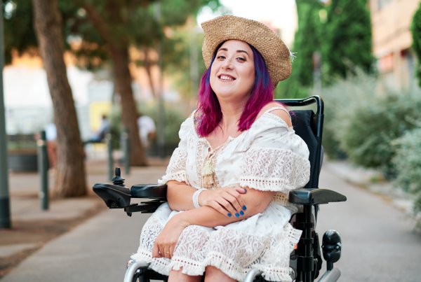 A woman in a wheelchair smiling.